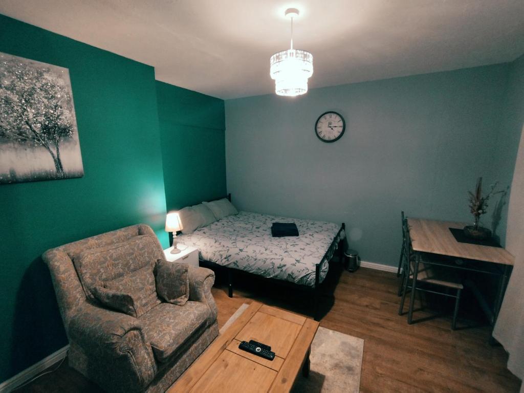 Cette chambre comprend un canapé, un lit et une chaise. dans l'établissement We love Henbury, à Bristol