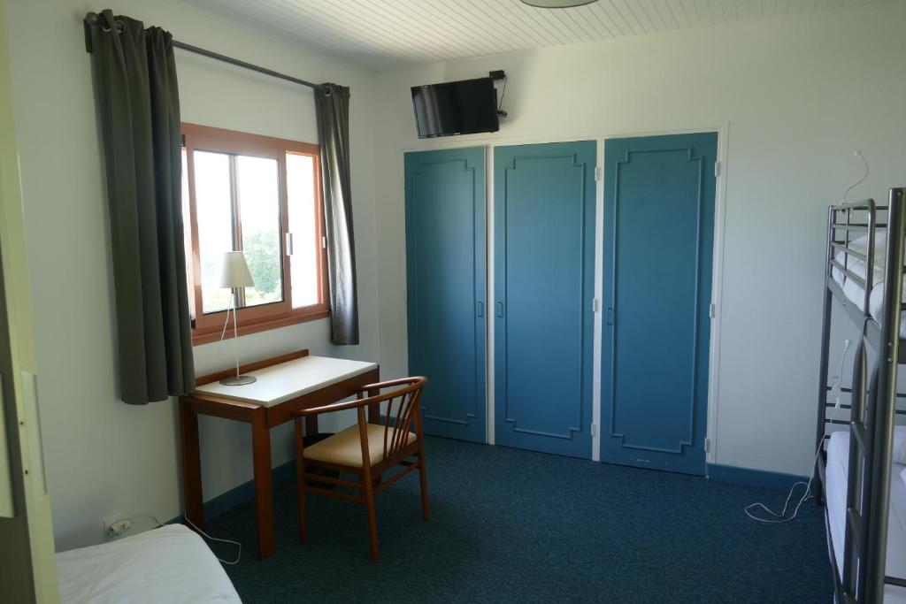 a room with a desk and a bed and a window at Kerbugalic Grand gîte, Magnifique vue mer in Trévou-Tréguignec
