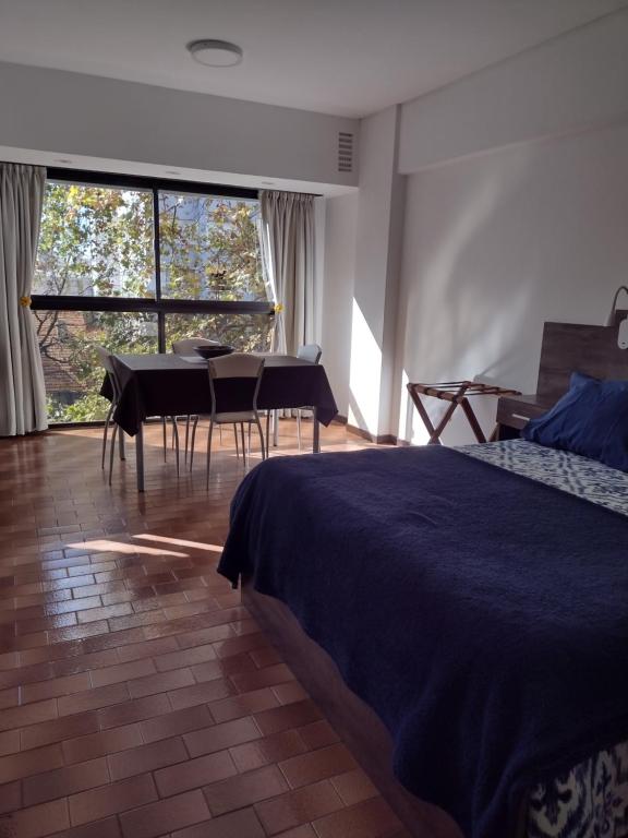 1 dormitorio con 1 cama, mesa y sillas en Luminoso Ambiente, con cochera en lo mejor de La Perla en Mar del Plata