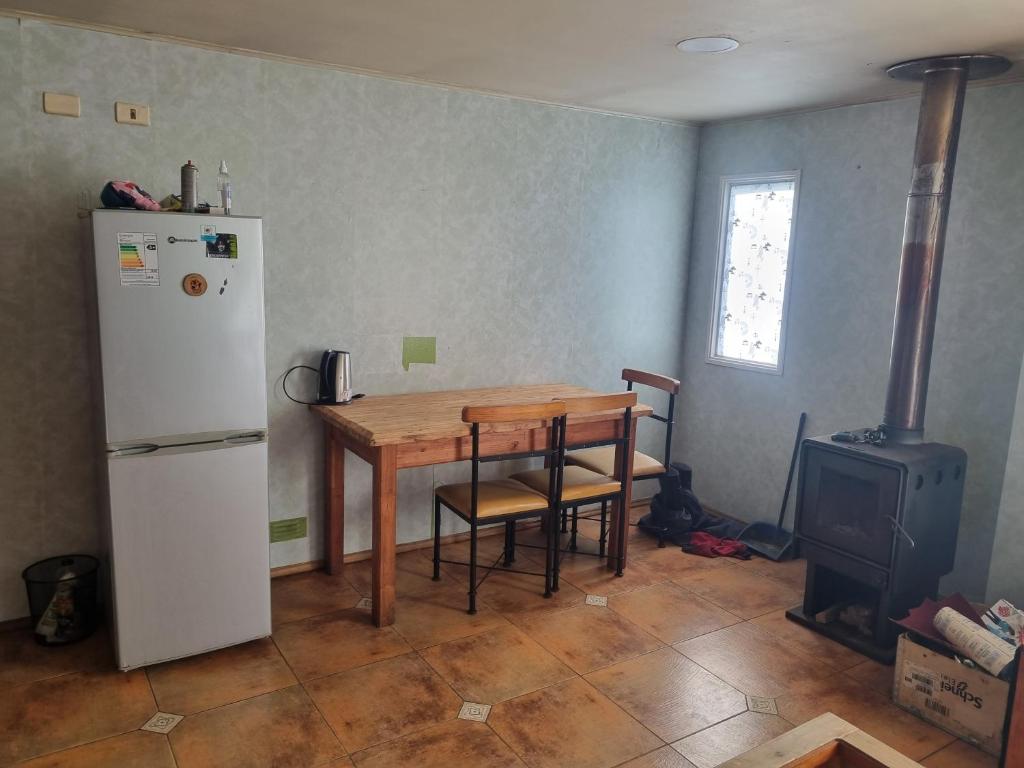 uma cozinha com uma mesa, um frigorífico e um fogão em Casa completa em Castro