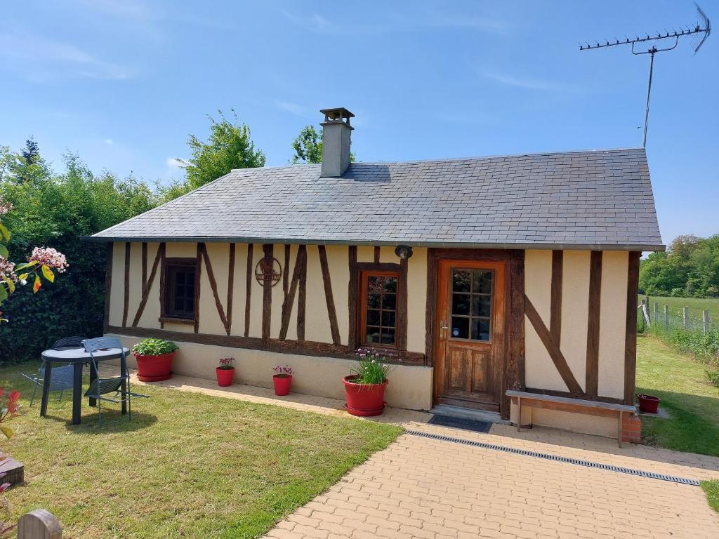 Cabaña pequeña con mesa en el patio en La Champêtre, en Beaumesnil