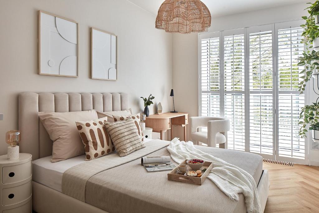 a white bedroom with a large bed and a table at ŻOLI STORK APARTMENTS - Hubnera 5 in Warsaw