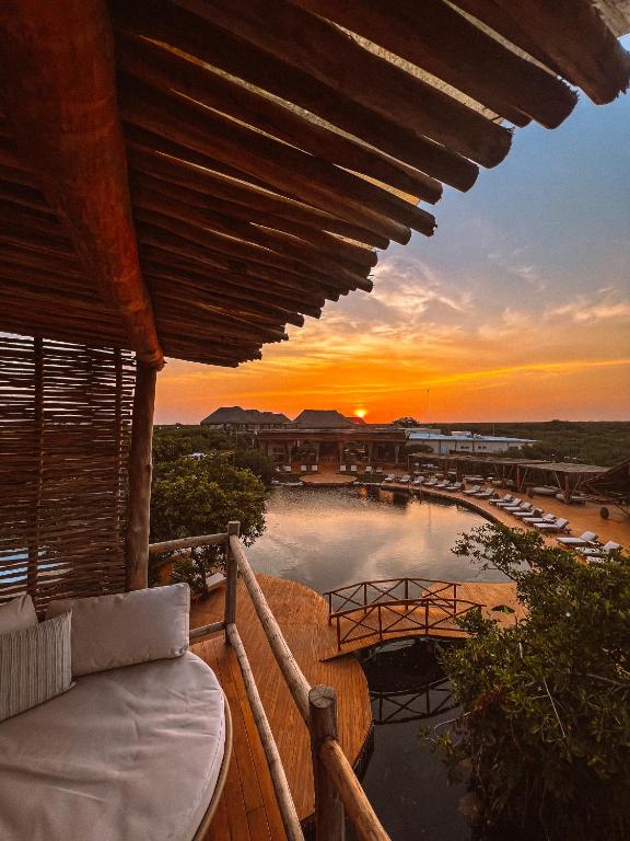 a sunset from a resort balcony with a pool at Hotel Shibari - Restaurant & Cenote Club in Tulum