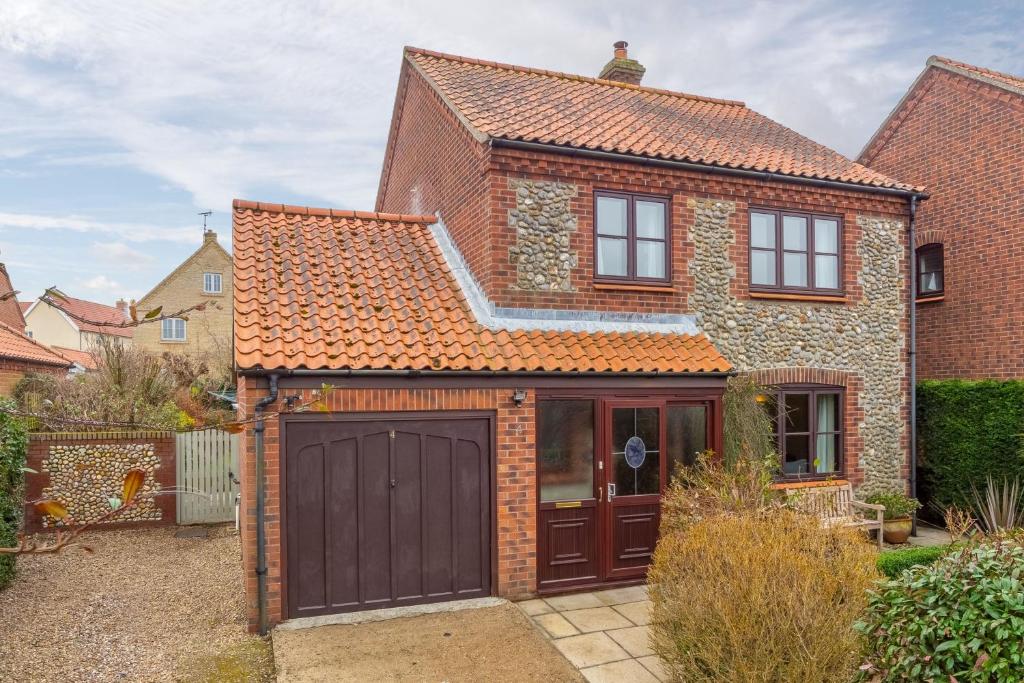 a detached house with a garage and a driveway at Arisaig in Wells next the Sea
