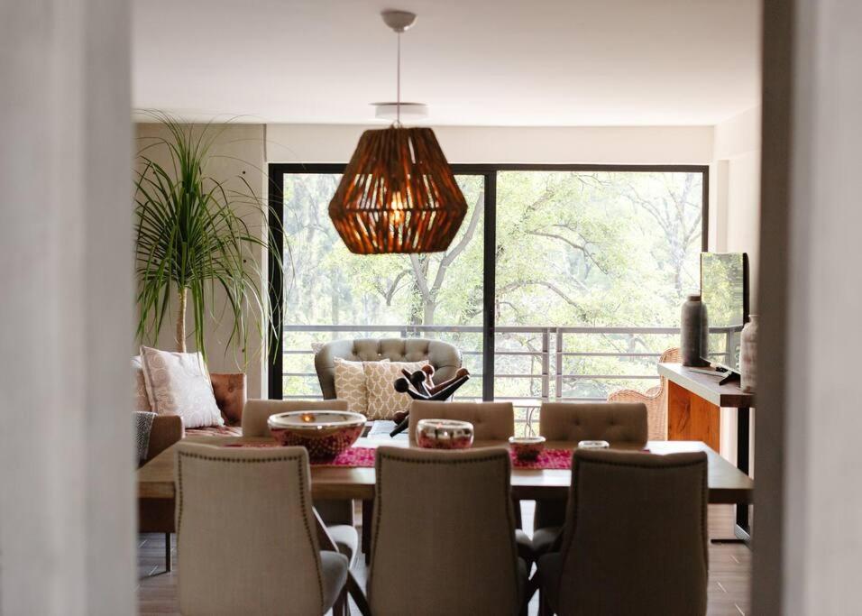 a living room with a dining room table with chairs at Mr. W Park View Balcony Espana 602 in Mexico City