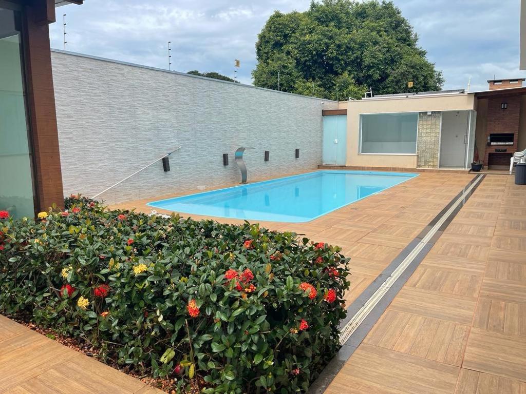 a swimming pool on top of a building with flowers at Casa da Leila in Piumhi