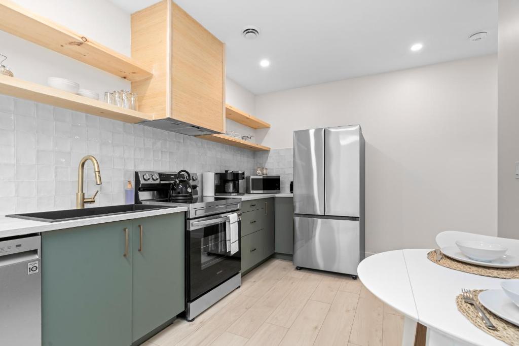 a kitchen with stainless steel appliances and a table at The Olympia: Front Street Flats in Belleville