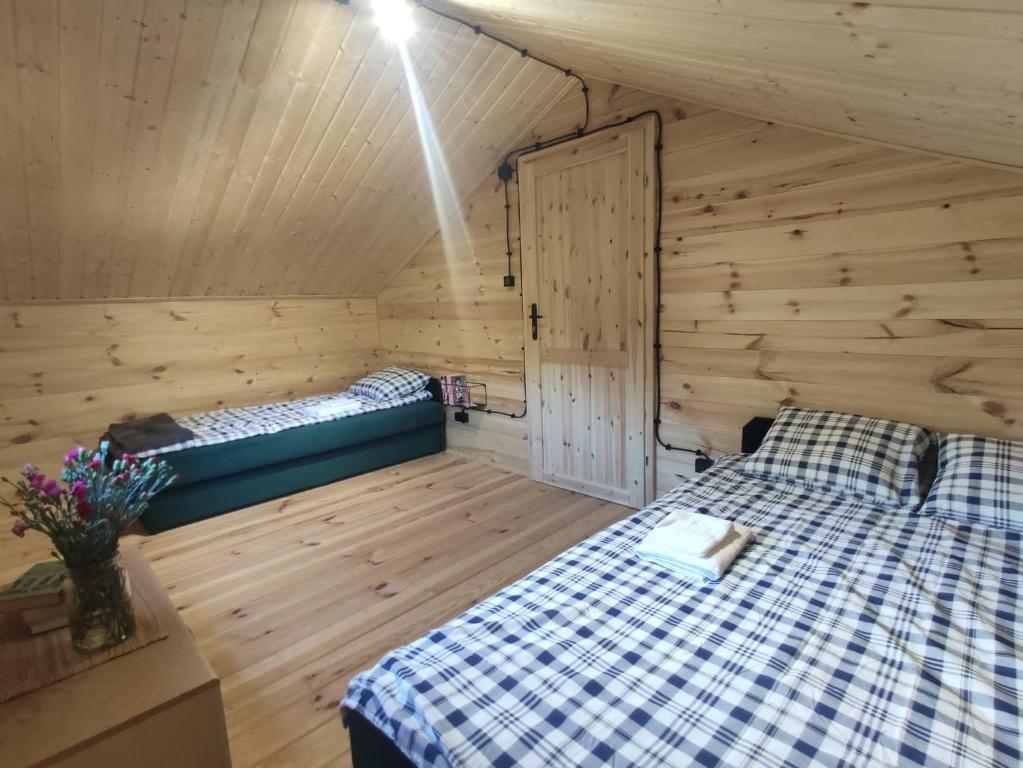 um quarto com uma cama num chalé de madeira em Labalas- odpoczynek pośród przyrody em Chomiąża Szlachecka