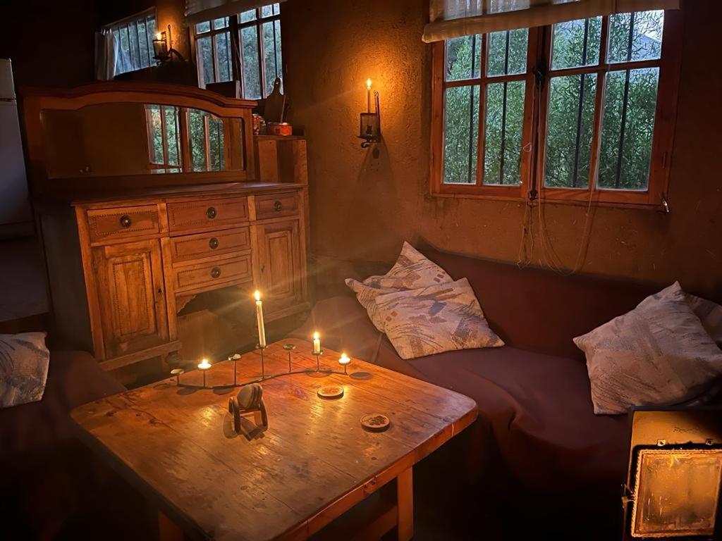 Una habitación con una mesa de madera con velas. en Alcohuaz Indomito, en Alcoguaz