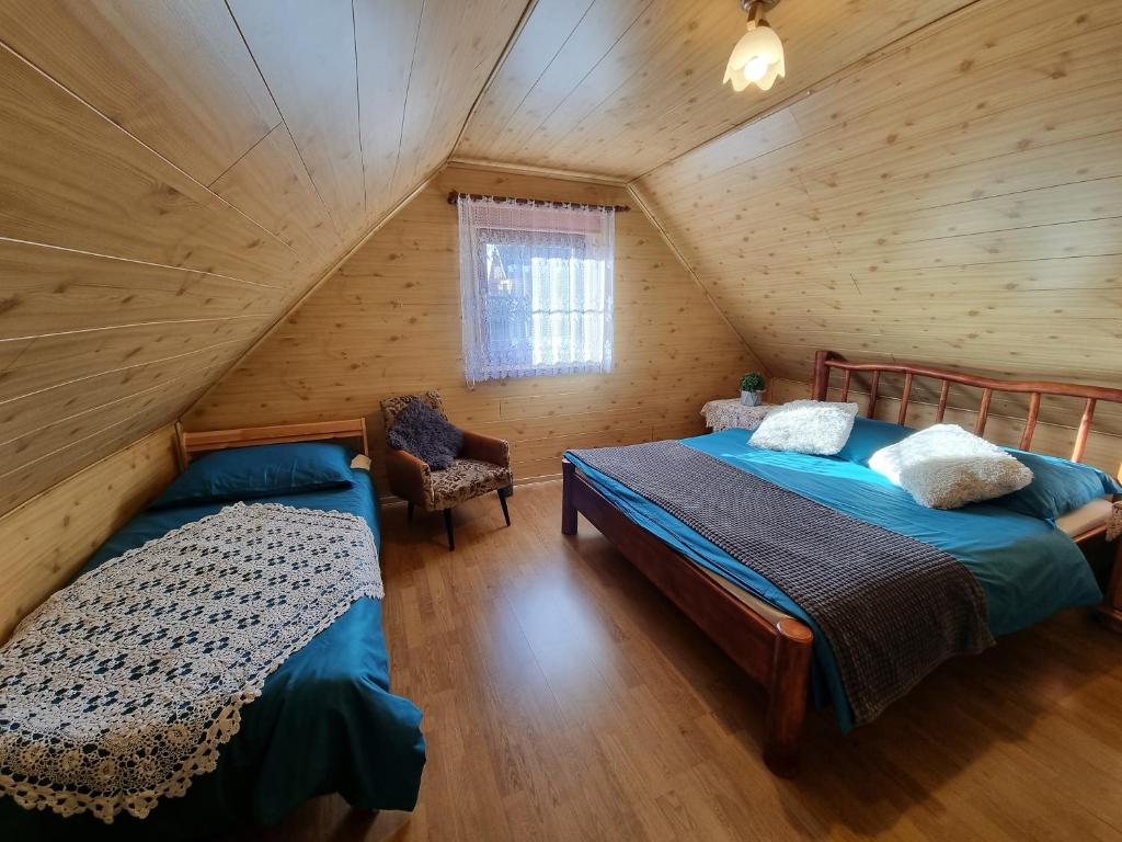 a bedroom with two beds in a log cabin at Koronkowa Chatka w Beskidach in Istebna