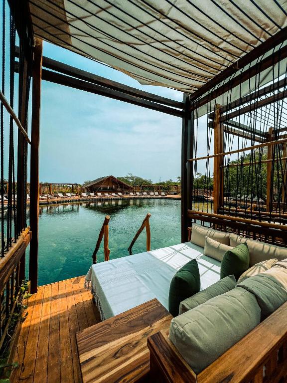a room with a couch and a view of a body of water at Hotel Shibari - Restaurant & Cenote Club in Tulum