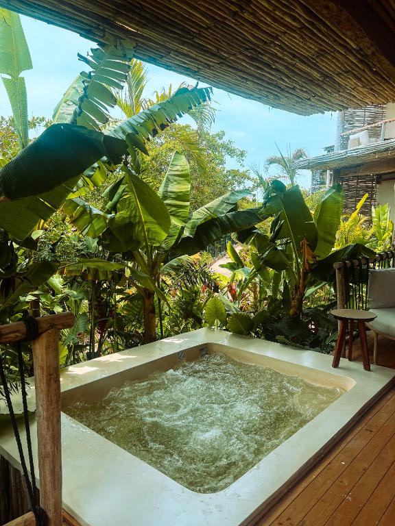 a hot tub in the middle of a garden at Hotel Shibari - Restaurant & Cenote Club in Tulum