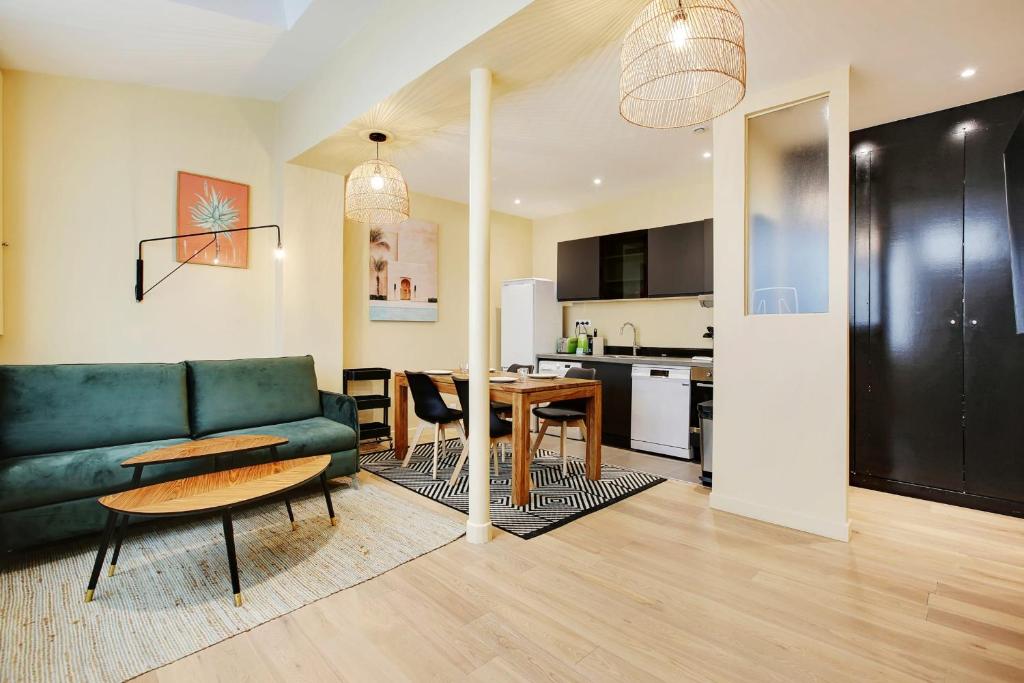 uma sala de estar com um sofá verde e uma mesa em New and bright apartment 4 people em Paris