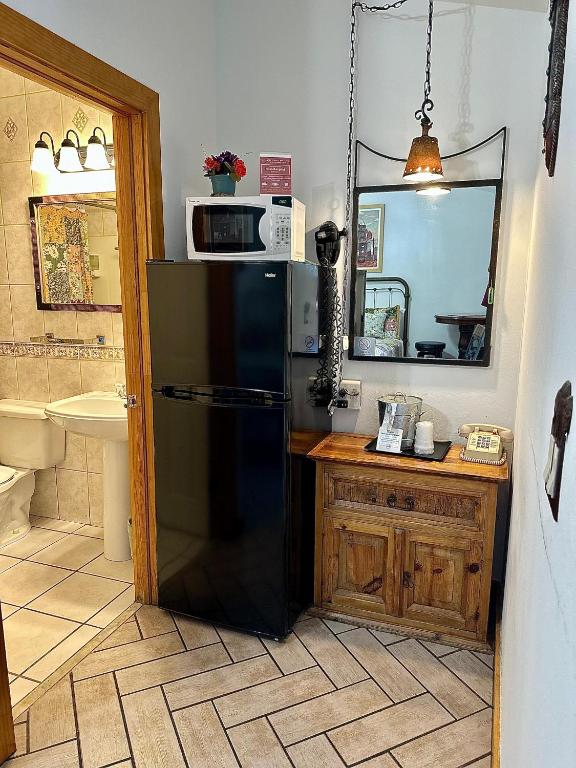 a kitchen with a black refrigerator and a sink at Buffalo Chip's Ranch House Motel in Bonita Springs