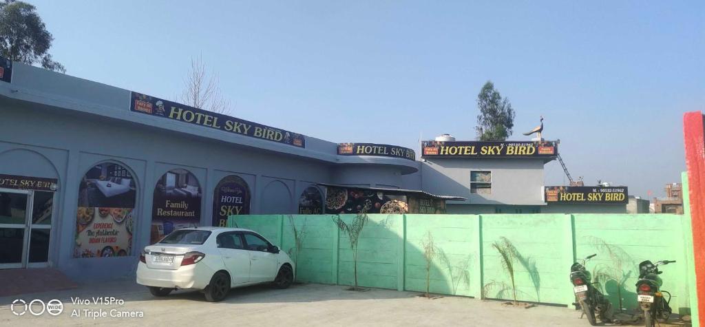OYO Hotel Sky Bird في Pehowa: سيارة بيضاء متوقفة أمام مبنى