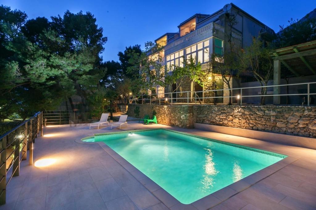 a swimming pool in front of a building at Villa Amari in Brela