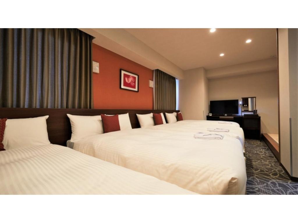 Y's Inn Naha Oroku Ekimae - Vacation STAY 25857v في ناها: غرفه فندقيه سريرين وتلفزيون