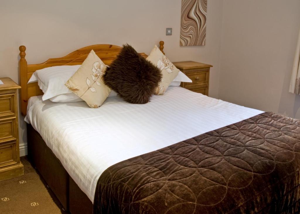 a bedroom with a bed with brown and white pillows at New Dungeon Ghyll Hotel in Great Langdale
