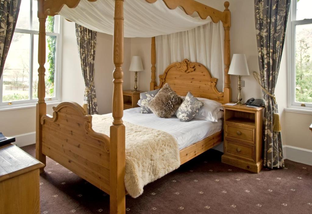 a bedroom with a canopy bed and two night stands at New Dungeon Ghyll Hotel in Great Langdale