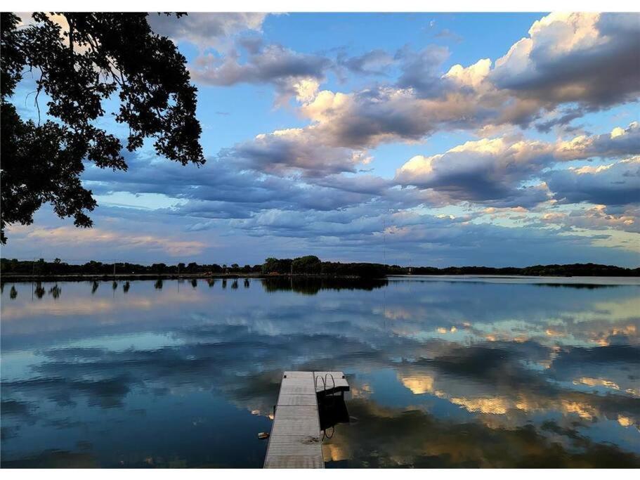 a dock on a lake with a cloudy sky at Over 200' of Shoreline on Foot Lake!! Great Fishing Year Round! in Willmar