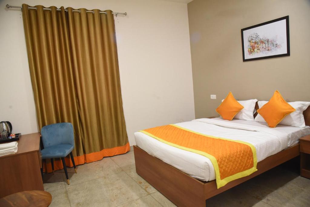 um quarto com uma cama, uma secretária e uma janela em Southern Grand Kashi - Inside Kashi Vishwanath Temple Corridor em Varanasi