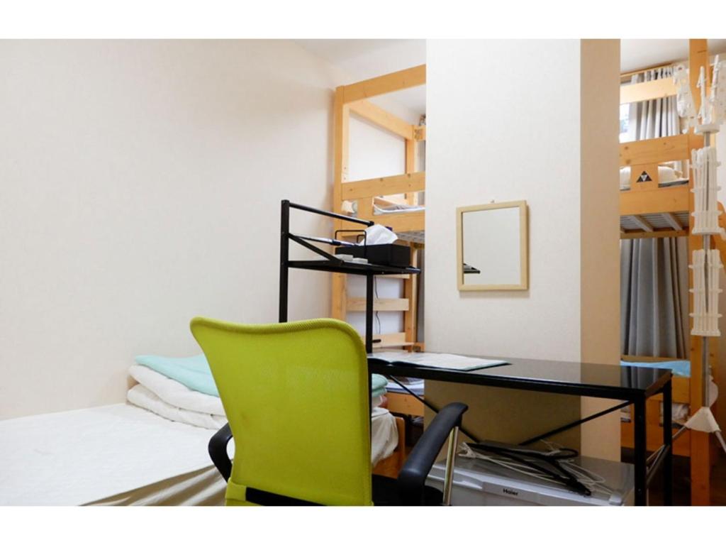 a room with a desk and a green chair at Tottori Guest House Miraie BASE - Vacation STAY 41214v in Tottori