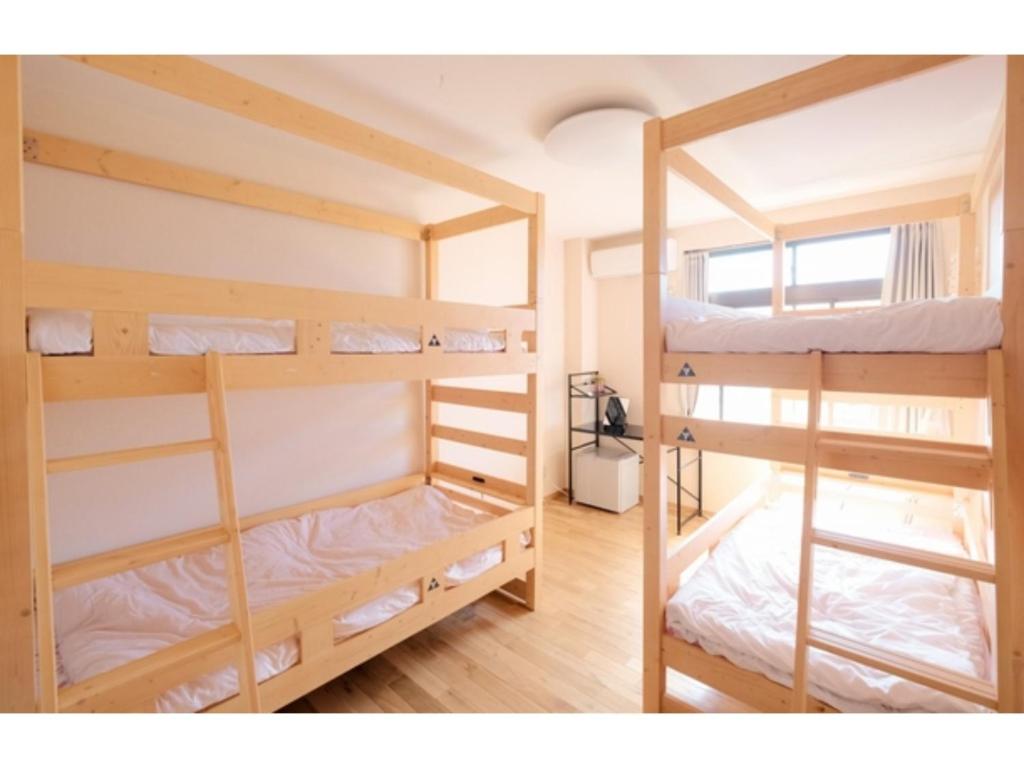鳥取的住宿－Tottori Guest House Miraie BASE - Vacation STAY 41221v，带窗户的客房内的两张双层床