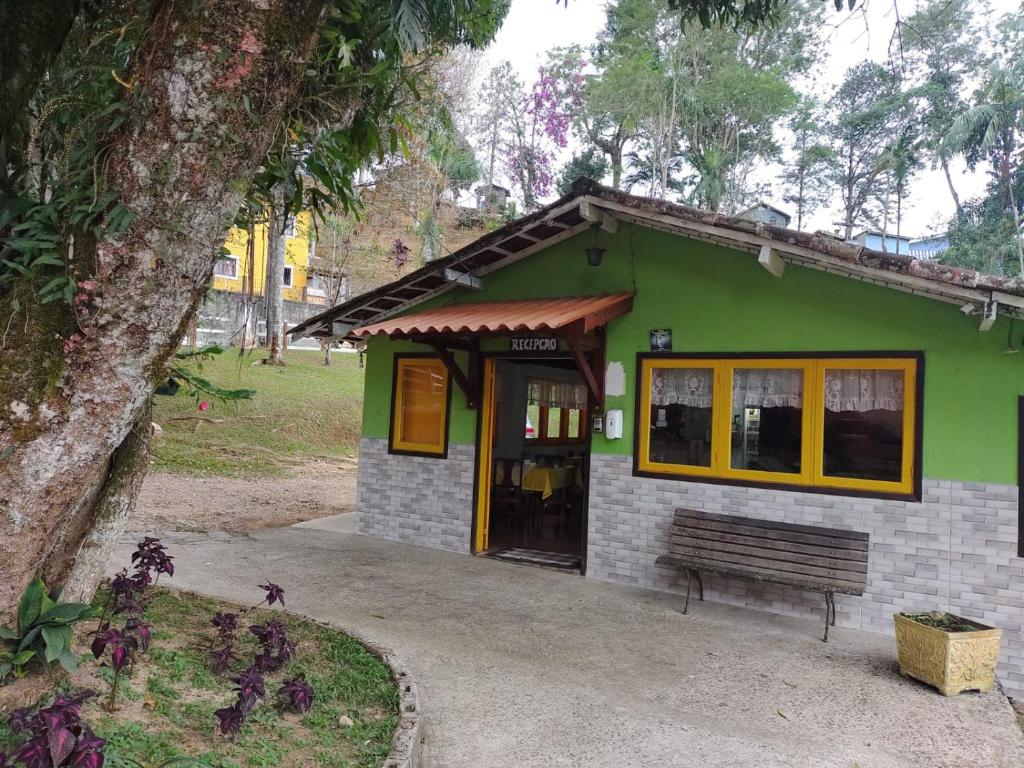 a green building with a bench in front of it at Pousada Bela Vista in Penedo
