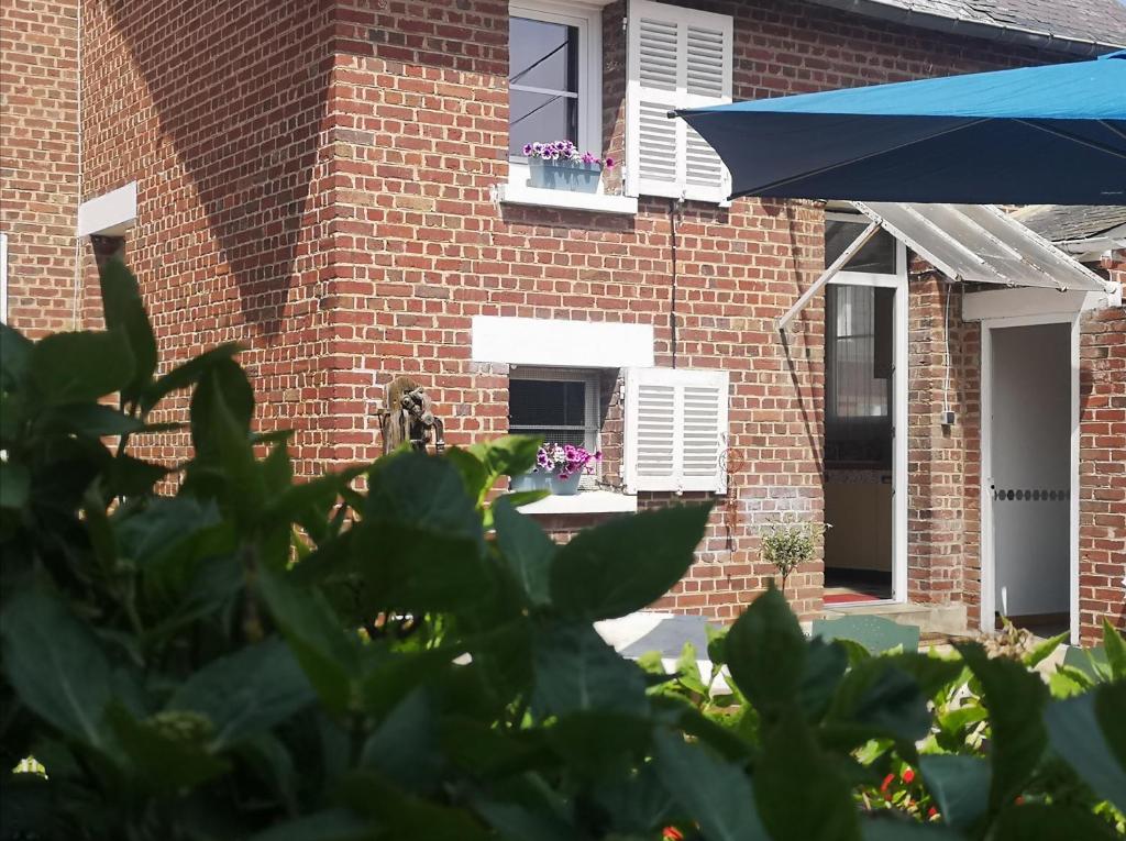 una casa in mattoni con finestra e ombrello blu di Le repos bien mérité a Nesle