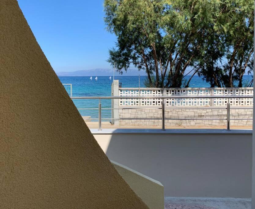 a view of the ocean from behind a fence at Blue Flag Award Winning Ormos Lo Beach: Home 1 in Vrontádos