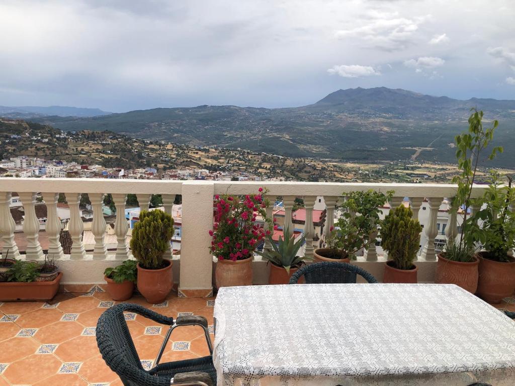 d'une table et de chaises sur un balcon avec vue. dans l'établissement Mina House, à Chefchaouen