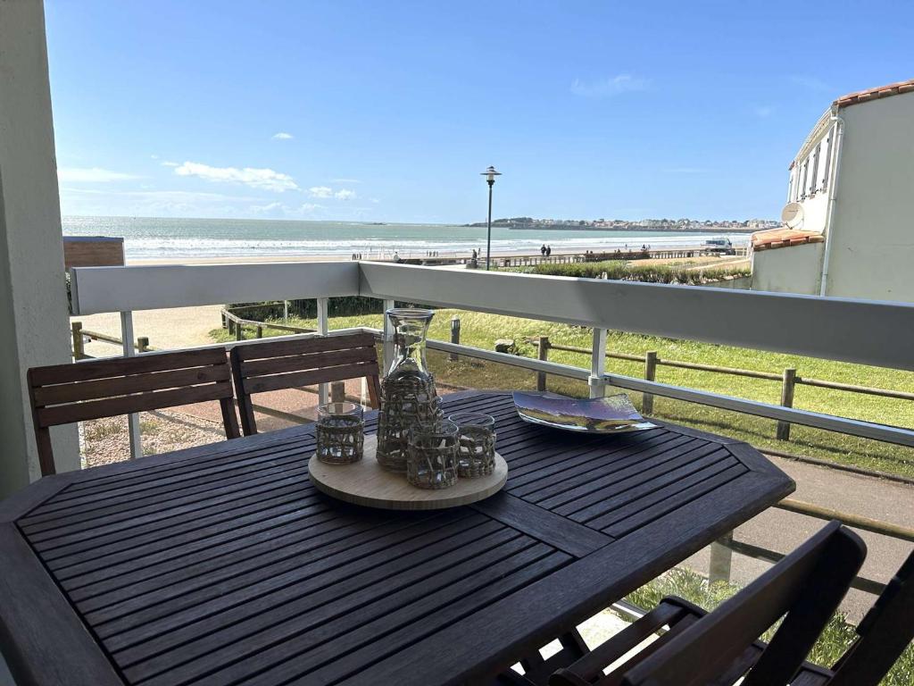 una mesa en un balcón con vistas a la playa en Appartement Saint-Gilles-Croix-de-Vie, 2 pièces, 4 personnes - FR-1-224-799, en Saint Gilles Croix de vie