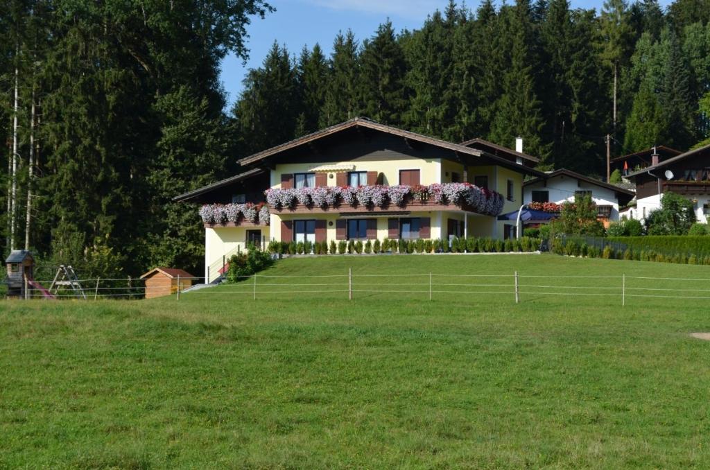 a house on a hill with a green field at Am Randersberg - Wohnung Nr 1 in Grossgmain