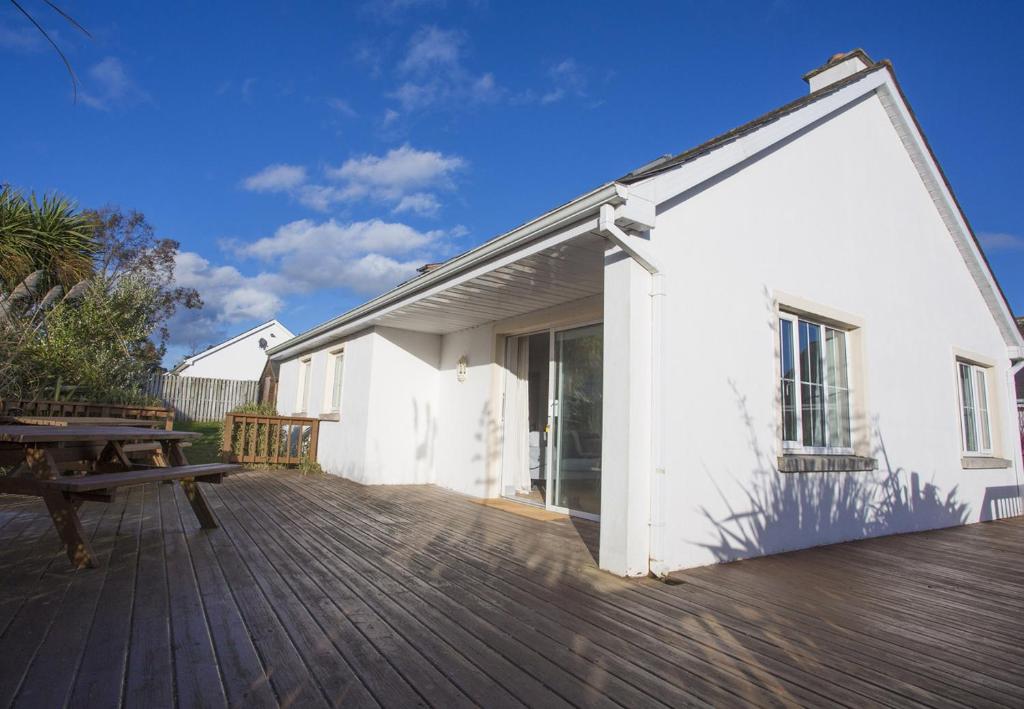 un edificio blanco con una mesa de picnic en una terraza en Brittas Bay Park Holiday Home No 44, en Brittas Bay