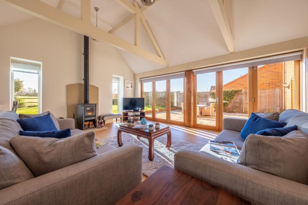a living room with two couches and a table at Saltings House in Ringstead