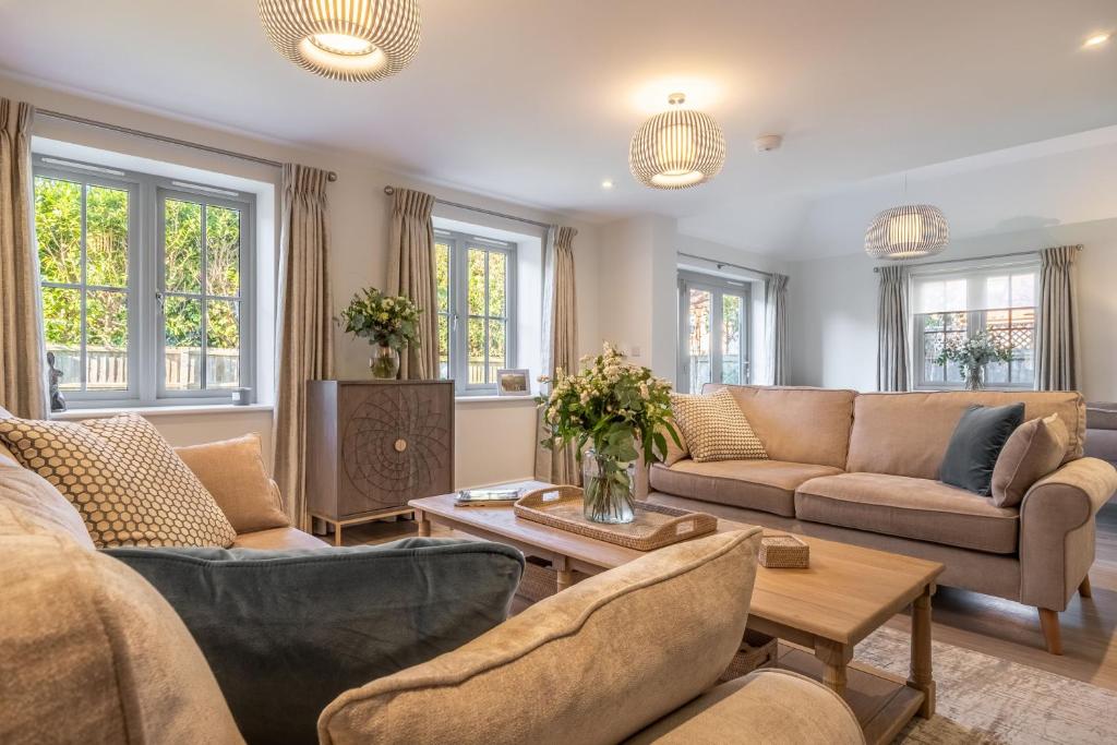 a living room with couches and a table at Bluebell Cottage 4 in Thornham