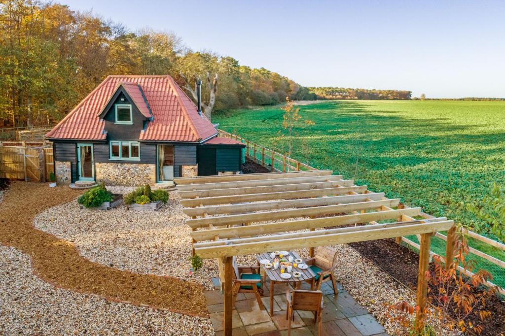 a small house with a red roof in a yard at Bumblebee Cottage 