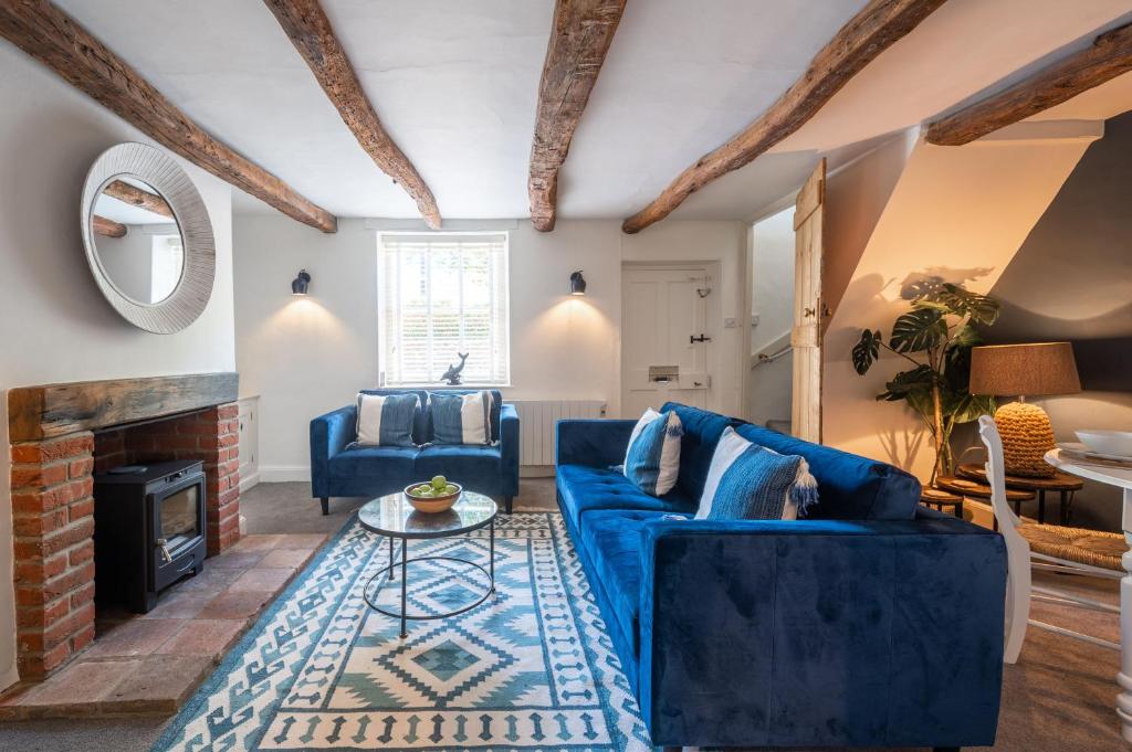 a living room with blue furniture and a fireplace at 154 Blakeney High Street in Blakeney