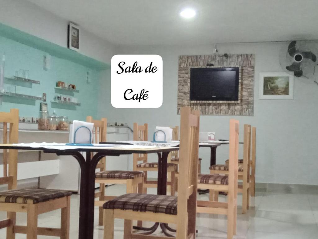 a dining room with tables and chairs and a tv at Hospedaria Monumento in Sao Paulo