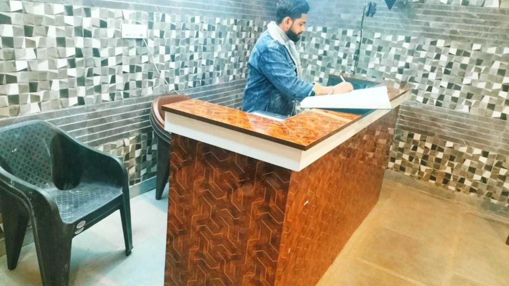 a man standing at a counter in a bathroom at Ms Residency in New Delhi