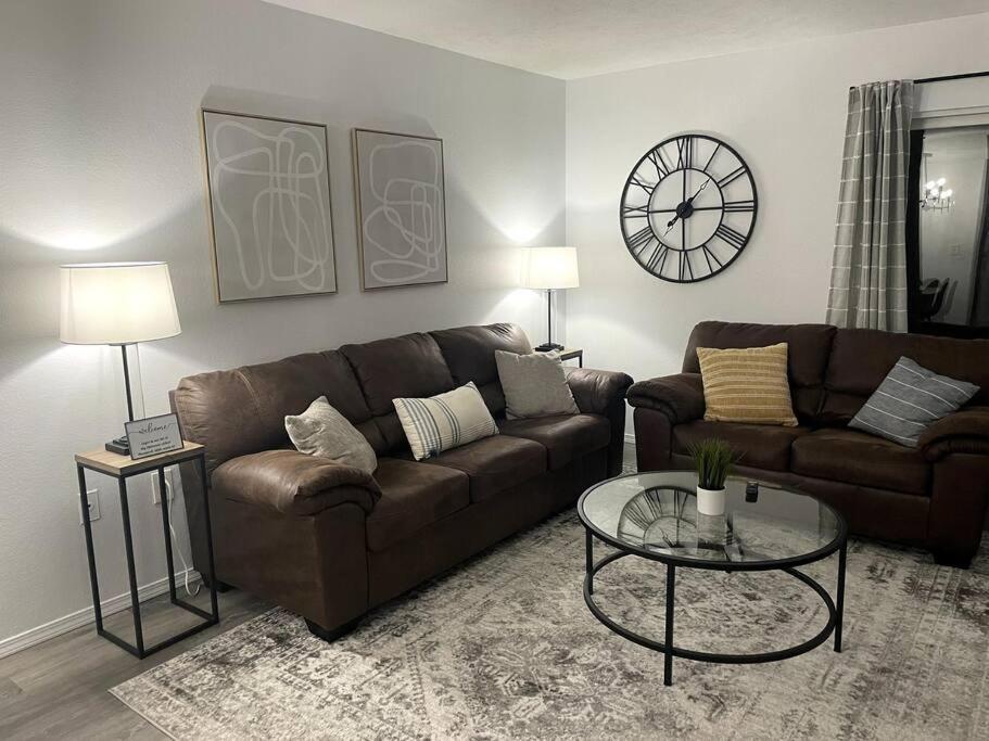 a living room with a brown couch and a glass table at Luxury Modern Condo by the Lake - Breezy Escape in Branson