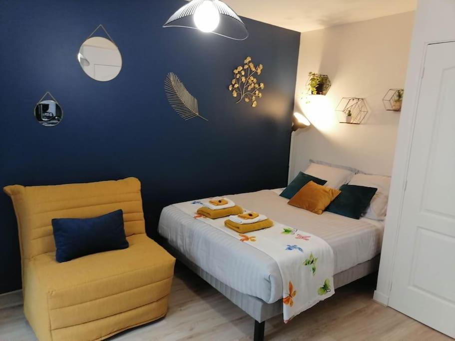 1 dormitorio con 2 camas y silla amarilla en Aux cocons Précignéens : Studio Bleuet, en Précigné