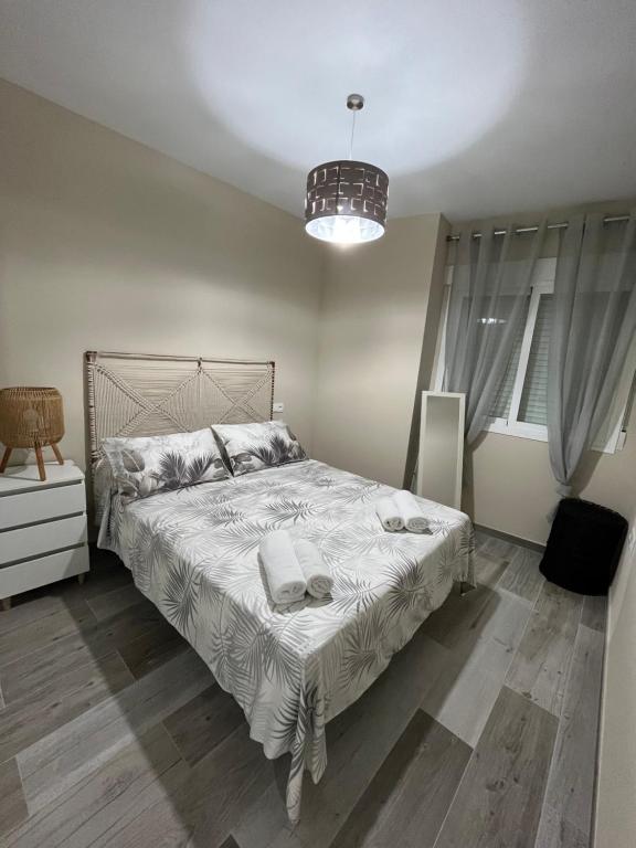 una camera con letto e lampadario a braccio di Apartamentos PENSI a Jódar