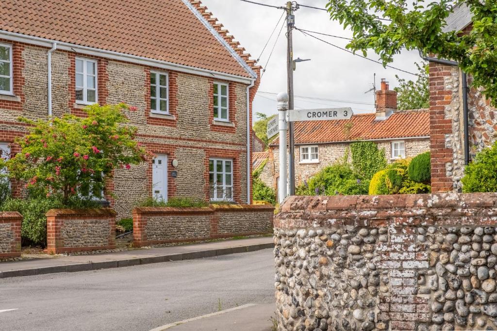 a street sign in front of a brick building at Birch Cottage in Northrepps