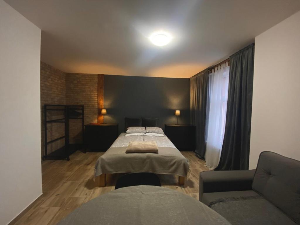 une chambre d'hôtel avec deux lits et un canapé dans l'établissement Polonia, à Polanica-Zdrój