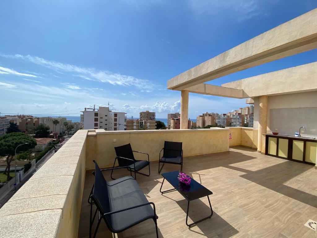 een balkon met stoelen en een tafel in een gebouw bij Attic with great terrace close to the sea in El Campello