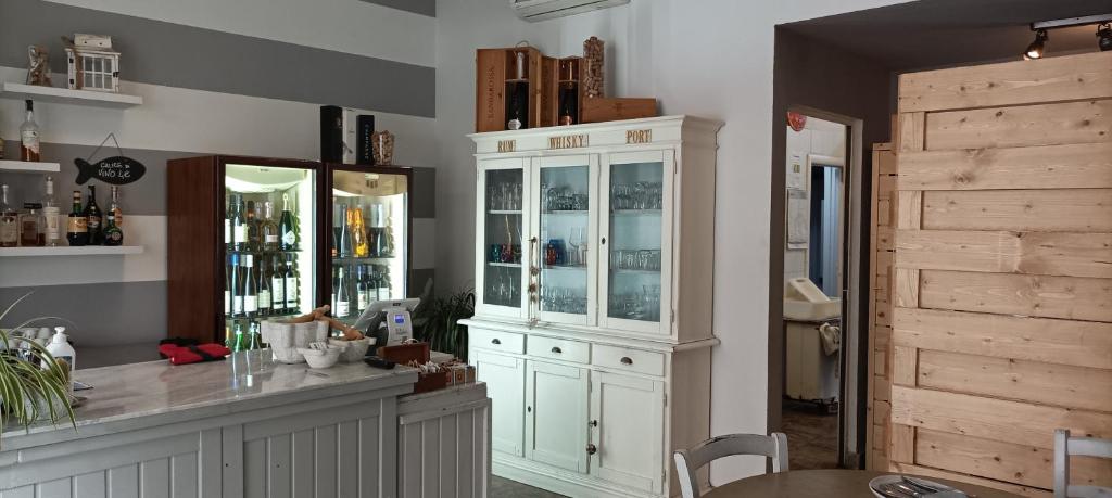 une cuisine avec une grande armoire blanche et une table dans l'établissement La casina di Ale, à Marina di Carrara