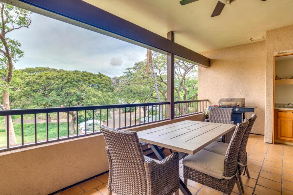 einen Balkon mit einem Holztisch und Stühlen in der Unterkunft K B M Resorts KRO-Q301 2Bedroom Ocean Views with Free Rental Car in Kaanapali