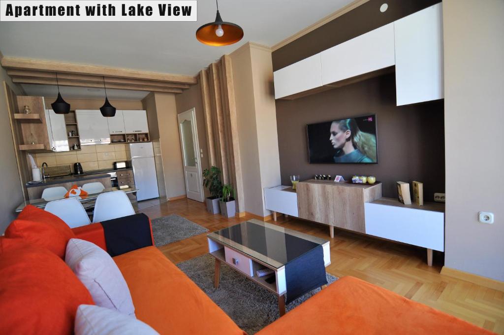 a living room with an orange couch and a kitchen at Apartments FANTASY in Ohrid