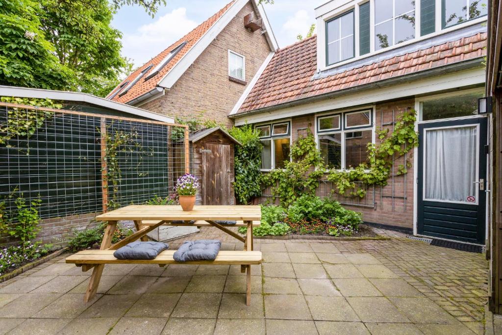 a wooden picnic table in front of a house at B&B Hendricus in Hoofddorp